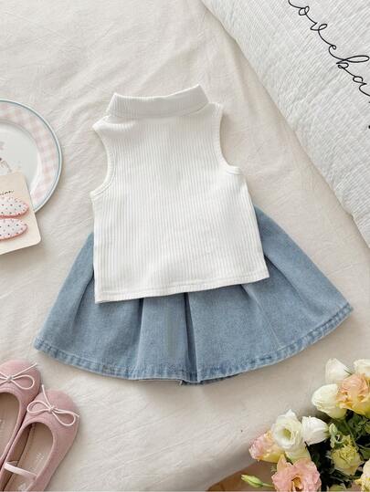 Vintaside Kids Bộ đồ ngắn tay không tay cho bé gái, áo màu trắng ngà + chân váy denim xanh nhạt. Áo không tay, chất liệu co giãn, cổ polo, dệt kim với nơ hồng thêu trên ngực. Chân váy ngắn bằng vải denim màu xanh nhạt với chi tiết nơ trắng thêu. Kiểu dáng tổng thể ngọt ngào, dễ thương và trẻ trung, phù hợp cho mùa hè, đi chơi hàng ngày, đi học mẫu giáo, dự tiệc và các dịp thư giãn gia đình.