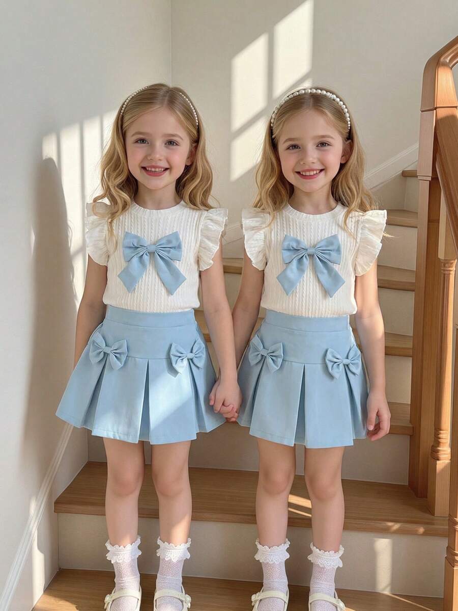 两件套女童白色提花针织圆领荷叶袖T恤，饰有蓝色蝴蝶结，搭配蓝色梭织松紧腰半身裙，适合春夏日常穿着、外出、度假、派对。浅蓝色半身裙套装，女童蝴蝶结服装，女童半身裙套装，两件套女童可爱复古风夏季格子裙，蝴蝶结打结套装。 - 彩色 - 查看 1
