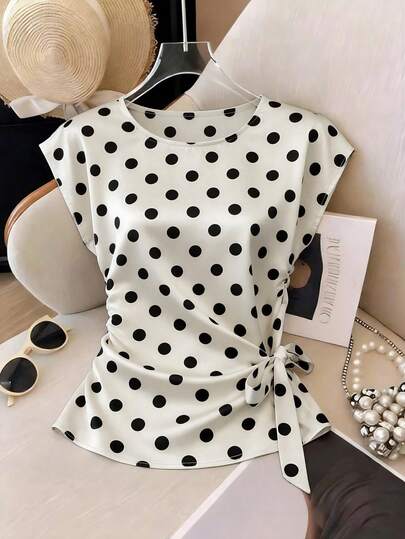 Franclia Women's New Collection Elegant Casual Outfit For Travel, Vacation, Commuting, Office, Sister Outings, Shopping, Old-Money Style, Daily Wear. Sensual Shoulder Sleeve Top – Base Color: Crescent White; Pattern: Black Circles. The Top's Right Side Is Tied Into A Delicate Bow At The Waist. Short Sleeve, Asymmetrical Hem. Suitable For Concerts, Gatherings, Dates, Casual Outings, Summer Wear, Carnival Outfits, Party Tops, Music Festivals. White T-Shirt, Black T-Shirt. White Top, Black Top. Perfect For The Vacation Season. Versatile For Summer Wear. Fabric Is Polka-Dot Satin, Shiny, Soft, Comfortable, High-End Feel. Machine Washable. Comfortable Fit