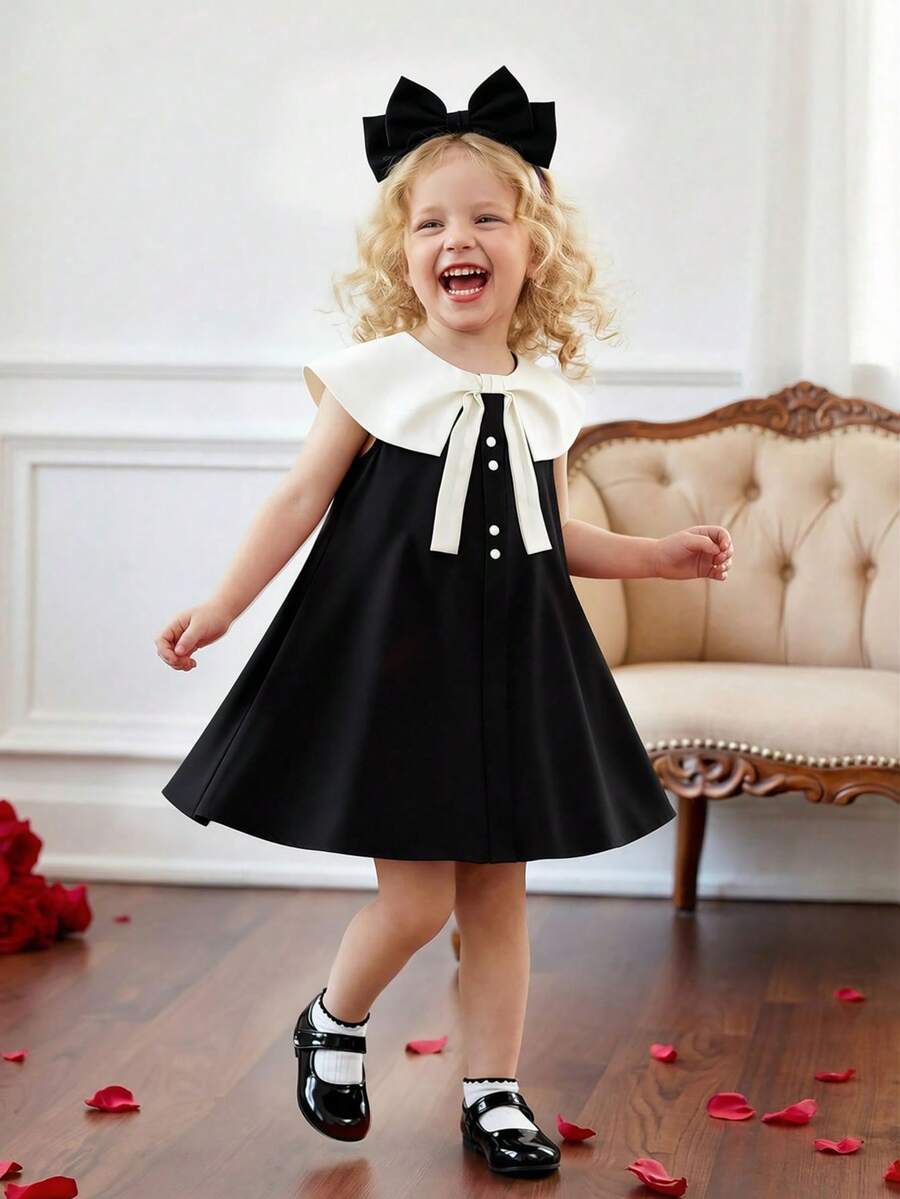 SHEIN 这款女童无袖连衣裙采用超大白色彼得潘领和蝴蝶结装饰，领口饰有珍珠纽扣，简约设计兼具可爱与优雅，适合夏季参加派对、聚会等轻度正式场合。