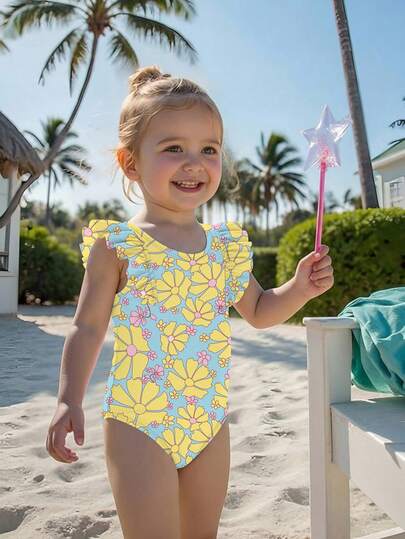 一件装女婴黄色碎花泳衣，荷叶边装饰，修身设计，适合度假、海滩、海边、夏季、游泳池、旅行、假日穿着。