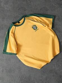 PAVTROS 这款男士宽松插肩袖T恤，采用黄色足球球衣设计，袖口和领口饰有绿色和黄色滚边，左胸印有绿色队徽，背面印有醒目的绿色“BRASIL”字样和黄色数字“7”。适合运动、休闲、日常穿着、返校季等各种场合，也是送给男友、丈夫或情侣的绝佳礼物。黄色男士T恤 - 黃色 - 查看 3