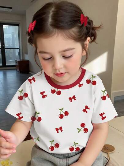 Camiseta de manga corta de cuello redondo casual y cómoda para niñas, diseño de estampado de cerezas y lazos de primavera/verano, cuello de color contrastante, ligera y transpirable, adecuada para uso al aire libre, casual, escuela, fiesta, regalo