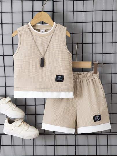 Ensemble casual pour garçons avec débardeur à col rond avec imprimé lettres et écussons, et shorts. Tissu gaufré confortable, pour le printemps/été