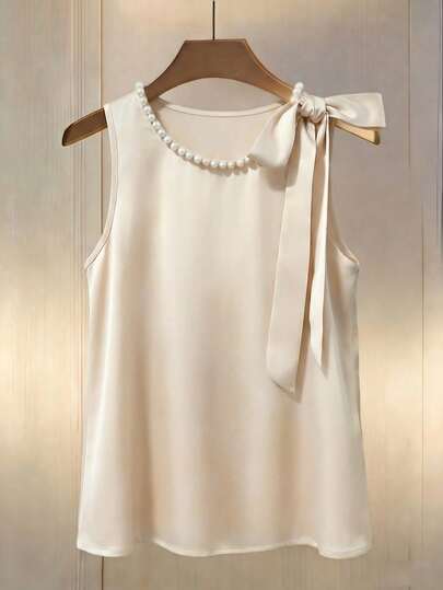 Franclia This Women's Champagne-Colored Elegant Satin Round-Neck Vest Blouse Is Perfect For Spring And Summer. Adorned With Pearl Embellishments, The Loose-Fitting, Sleeveless Apricot Satin Design Exudes French Elegance, Making It Ideal For Dates And Glamorous Outfits. A Cute Bow Detail At The Neckline Completes The Look. Suitable For Summer Tops, Women's Summer Wear, White Tops, Skirt Tops, Women's Office Wear, Women's Work Attire, Social/Professional Tops, Women's Casual Tops, Women's Elegant Tops, Weddings And Events, Weddings, Women's Beach Wear, Party Tops, Easter.Graduation Season Attire, Fashionable Casual Commuter Wear, Business Office Wear, Versatile And Stylish Everyday Casual Wear, Urban Teacher's Professional Attire