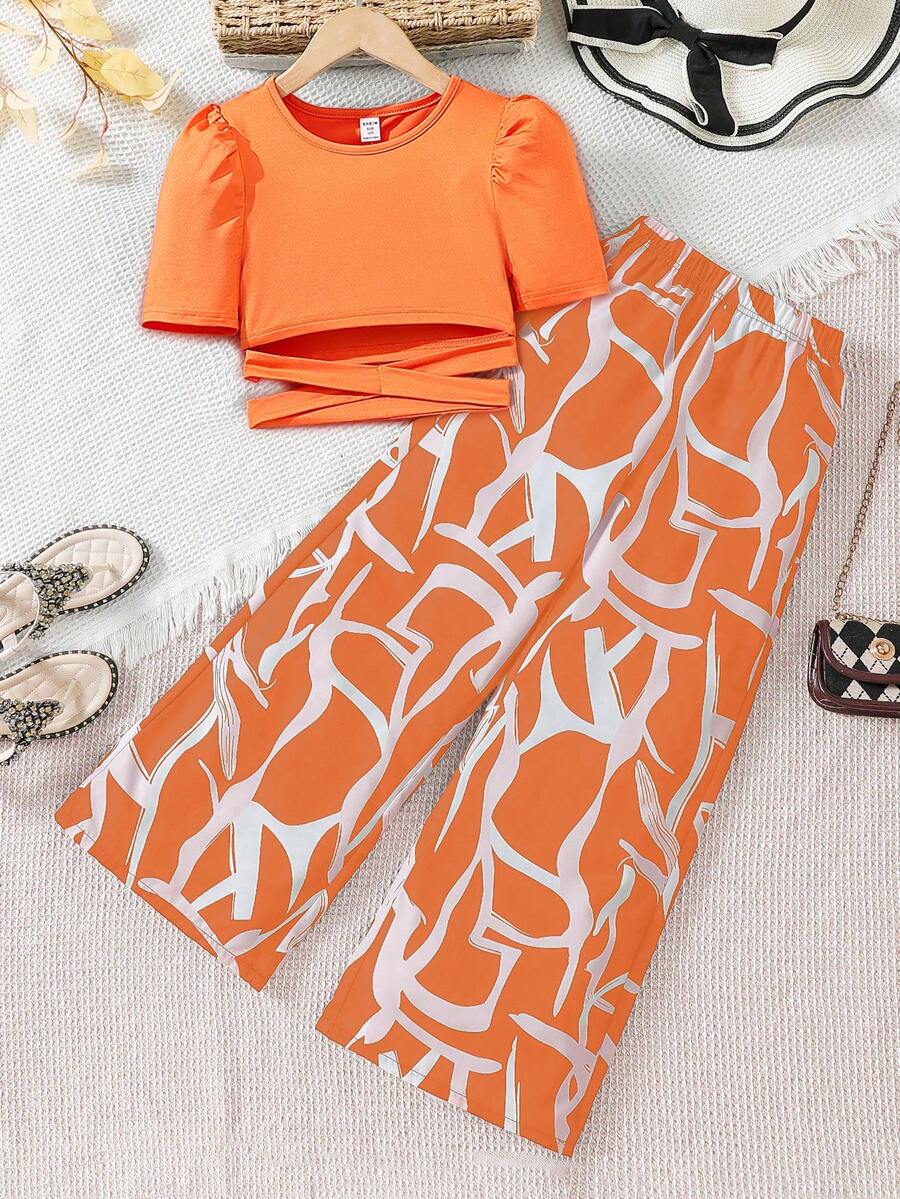 Sparklyn Bộ đồ thường ngày cho bé gái tuổi teen: áo thun cổ tròn tay cánh hoa màu trơn, vạt chéo và quần ống rộng in họa tiết. - trái cam - Xem 1