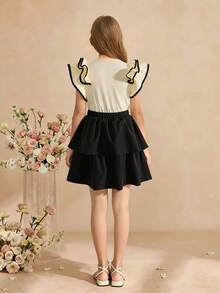 SHEIN Girls' Fashionable 2 Pieces Set: Apricot Knit Sleeveless Top With 3D Ruffle Trim And Contrast Drawstring, Paired With Black Layered Beaded Hem Skirt, Suitable For Daily Wear And Various Occasions - Apricot - View 2