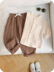 SHEIN 两件套男童休闲运动度假套装，包括一件白色翻领短袖衬衫和一条带松紧腰带口袋的纯色长裤，适合儿童穿着，也适合小男孩、返校季、生日派对、晚宴、演出、婚礼、情人节等场合，以及日常穿着、上学、旅行、运动、春夏季节。 - 杏色 - 查看 7