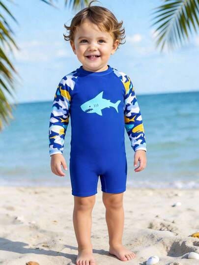 Traje de baño con cremallera para bebé, estampado de tiburón con vida marina. Un artículo de moda imprescindible para las vacaciones de verano en la playa. Diseño de manga larga, color de contraste azul, adorable estampado de tiburón y vida marina. Alegre y vívido. Adecuado para que los niños pequeños lo usen cuando jueguen en la playa.