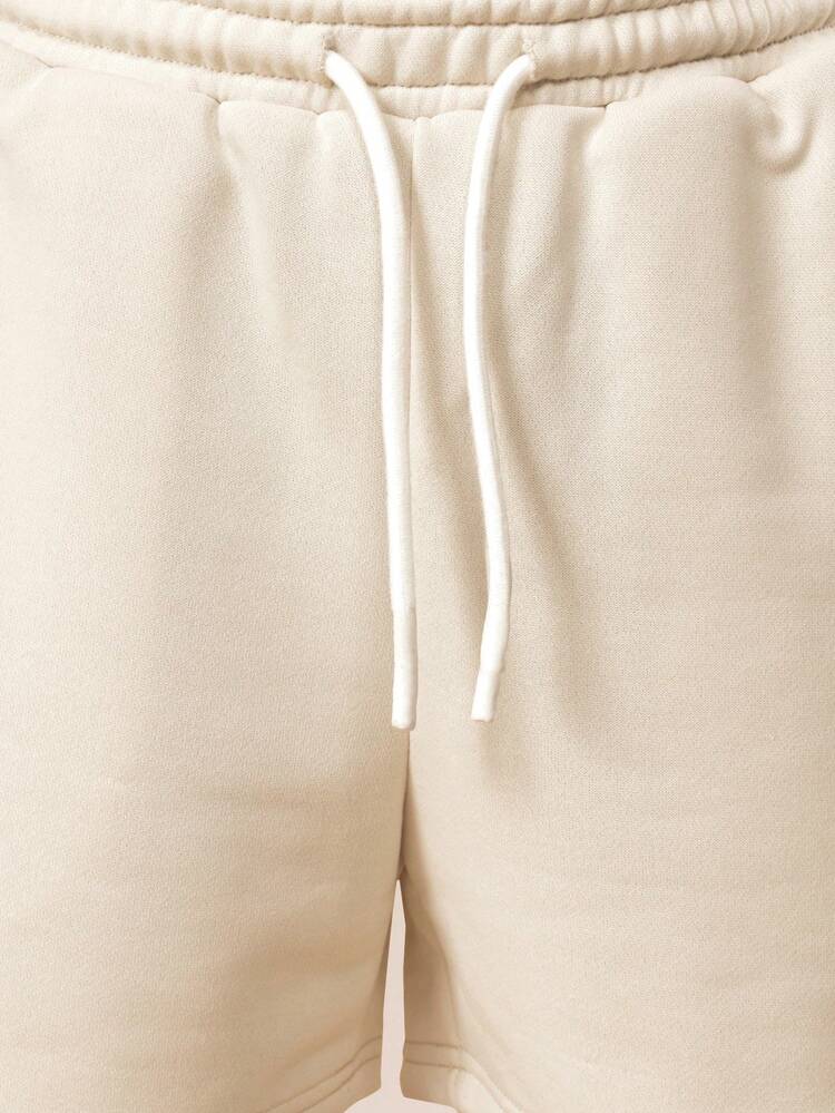 Set polo da ragazzo con pantaloncini abbinati, in colore crema beige, due pezzi coordinati, outfit estivo, stampa "East Coast State of Mind", stile casual preppy