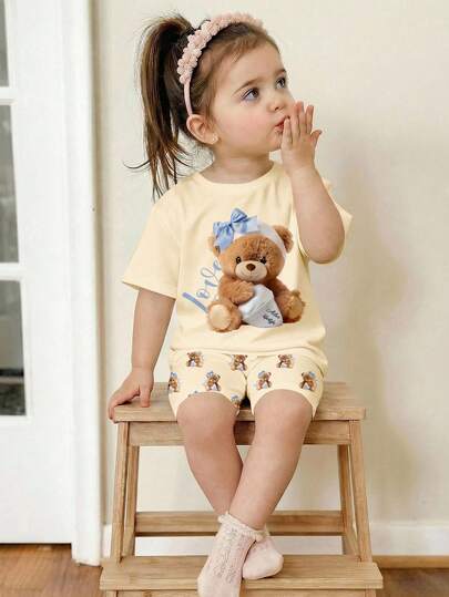SHEIN Baby Girl Cream Yellow, Adorable Butter Bear Print, Casual Minimalist Soft Round Neck Loose Short Sleeve T-Shirt And Tight Cycling Shorts Set, Suitable For Spring/Summer Daily Wear, Street Style, Outing, Home, Vacation, Picnic, Farm