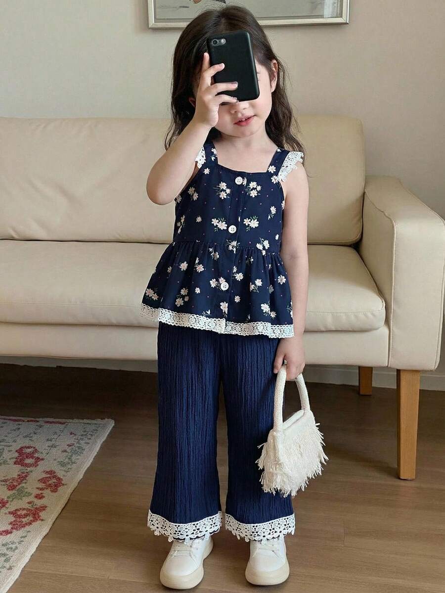 SHEIN Playful Pals 女童春夏套装，藏蓝色无袖上衣+配套阔腿裤；上衣采用吊带设计，饰以清新碎花图案，领口和下摆饰有白色蕾丝花边，尽显精致柔美；阔腿裤采用松紧腰带设计，裤脚同样饰有蕾丝花边，打造甜美清新的整体造型。轻盈舒适的面料，适合日常穿着。女童裤装上衣女童夏季套装2件套 - 寶藍色 - 查看 1