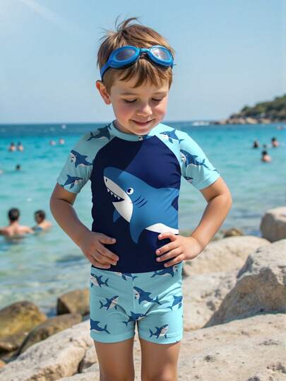 SHEIN Conjunto de ropa de baño informal y de moda para niño pequeño con estampado de tiburón y bloques de color, incluye camiseta de cuello redondo de manga corta y pantalones cortos, adecuado para el verano