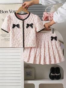 SHEIN This Two-Piece Set For Girls Features A Jacquard Short-Sleeved Top And A Pleated Skirt. An Elegant Two-Piece Spring/Summer Outfit, This Children's Jacquard Dress Is A New 2026 Spring/Summer Style Set For Girls, Featuring A Pink And White Jacquard Color-Blocked Short-Sleeved Top And A Pleated Skirt. It Includes A Delicate Black Bow Decoration And A Round Neck With A Single Row Of Pearl Buttons. This Two-Piece Set Is Perfect For Spring And Summer. - Multicolor - View 4