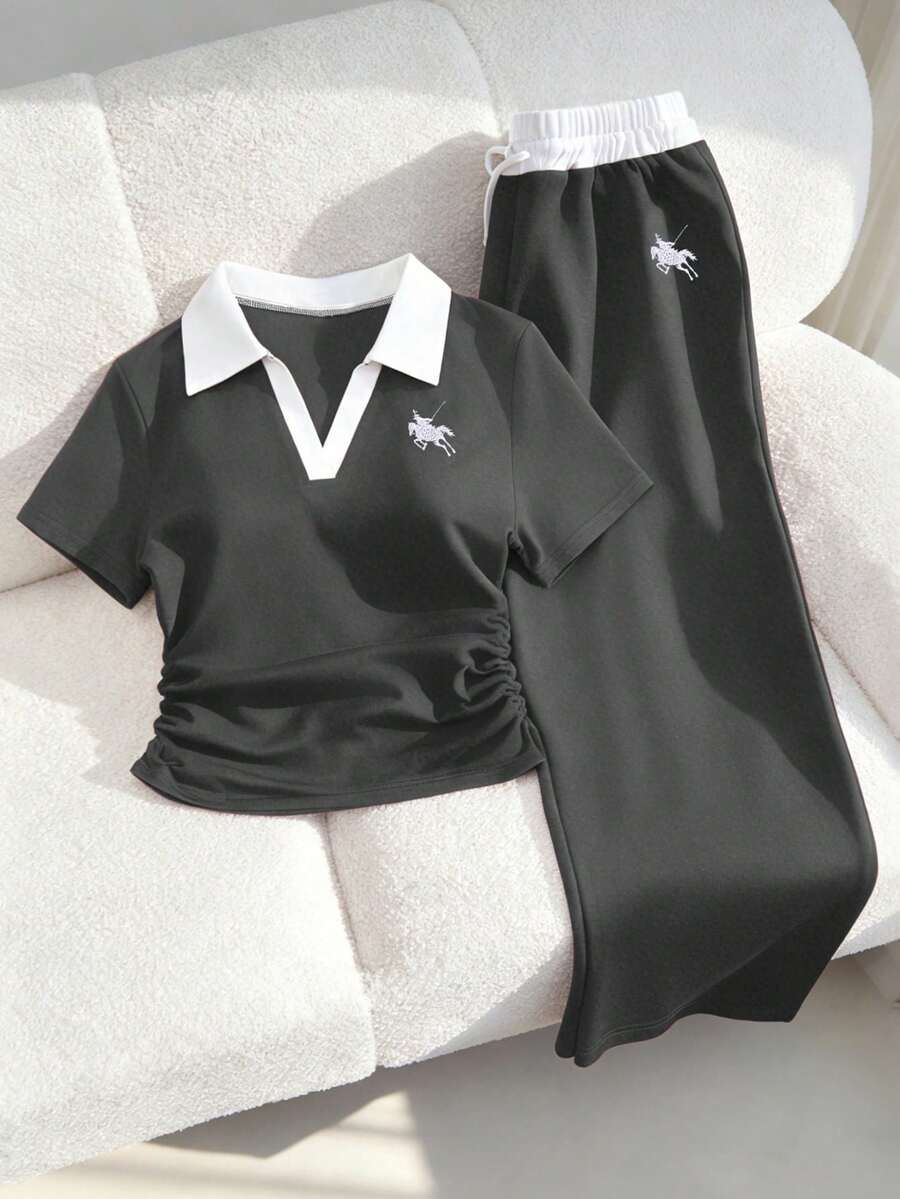 这款少女休闲运动套装，采用撞色缝线 Polo 领设计，胸前饰有刺绣，短袖上衣腰部设有褶裥，搭配阔腿抽绳裤。这款海军蓝运动套装完美兼顾舒适与时尚。精致简约的设计，可调节腰围的阔腿裤和撞色 Polo 领更能修饰颈部线条，使其成为居家休闲、运动健身或户外活动的必备夏季单品。
