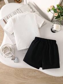 SHEIN Explorewe Conjunto de 2 piezas para niñas pequeñas con blusa de punto acanalado con volantes y decoración de lazo, falda-pantalón corta con abertura y perlas - Blanco y Negro - Ver 2