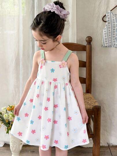 甜美可爱风女童吊带连衣裙，春夏款，白色，肩带饰以粉色花朵，裙身饰有彩色花朵图案，A字廓形，面料柔软舒适，时尚百搭，适合日常穿着。
