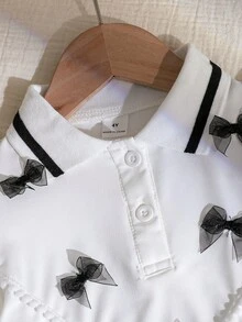 Genkimix Kids Bộ 2 món gồm áo polo tay phồng thắt nơ và chân váy xếp ly cho bé gái, đồng phục học sinh dễ thương, bộ váy áo cho bé gái. - Đen và trắng - Xem 2