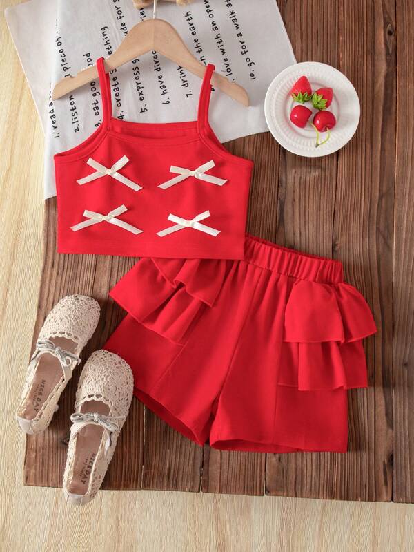 This Is A Festive Red Two Pieces Outfit For Little Girls, Featuring A Sleeveless Top With Bow And Ribbon Details, And Shorts With Layered Ruffles On The Sides. Perfect For Spring And Summer Birthdays, Parties, And Everyday Wear.