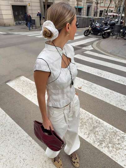 Nöista 修身款上衣，领口前部镂空设计。撞色滚边。质感面料。短袖，常规长度。适合节日度假、情人节以及春夏造型。