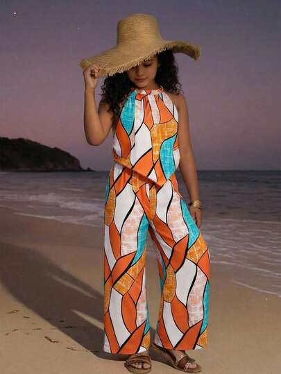 这款少女上衣采用露背弹力褶皱设计，搭配领带，尽显俏皮可爱；宽松飘逸的阔腿裤，让孩子活动自如。服装饰以活力四射的橙色、蓝色和白色几何图案，打造出引人注目又不失精致的视觉效果。这套服装适合度假、海滩、户外家庭聚会或休闲家庭出游等场合，既能营造轻松愉悦的氛围，又兼顾舒适与时尚。