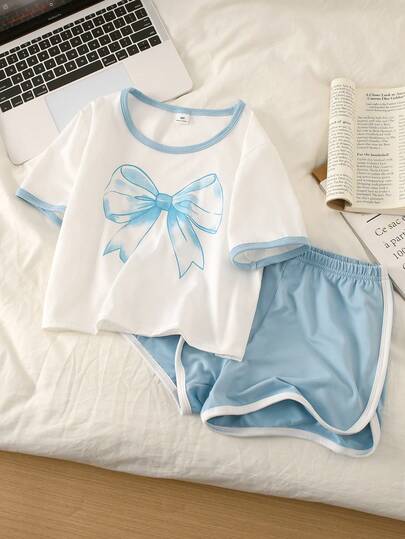 Conjunto de pijama de pantalón corto y blusa de manga corta con estampado de lazo azul dulce y refrescante para niñas, blusa de manga corta blanca con ribete de contraste azul claro en el cuello y los puños, estampado de mariposa azul claro en el pecho, pantalón corto azul claro con ribete blanco en el bajo, ropa de estar en casa con coordinación de moda
