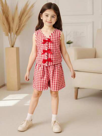 SHEIN 女童多色格子两件套，包括一件胸前饰有蝴蝶结的针织条纹背心和一条宽松舒适的松紧腰短裤。是春夏度假和日常休闲穿着的百搭之选。