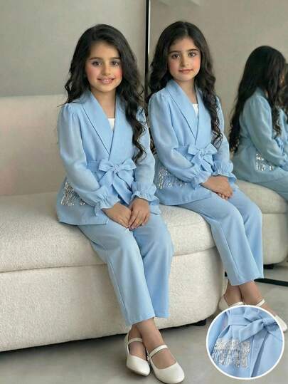 Bộ đồ thể thao phong cách Trung Đông thường ngày dành cho bé gái, gồm áo khoác màu trơn phối chiffon và tua rua, cùng quần màu trơn, phù hợp cho việc đi làm và mặc hàng ngày.