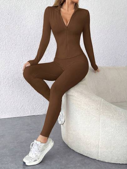 SHEIN PETITE 黑色两件套运动服，包括拉链外套和紧身裤。