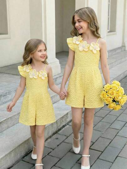 SHEIN Girls' Yellow Jumpsuit. One Shoulder, Single-Side Strap Design, With A Fashionable And Active-Friendly Style. Floral Decoration On The Shoulder Strap Adds Visual Highlights And Sophistication. This Fashionable And Casual Girls' Outfit Combines Sweet Elements, Suitable For Children's Daily Outings, Play, And Other Leisure Occasions, Balancing Aesthetics And Practicality.