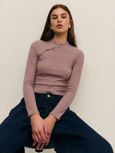 Nöista Elegant ribbad stickad topp med figurnära silhuett och asymmetrisk halsringning, färdig med kontrasterande detaljer och metalliska knappar. Sofistikerad och feminin, perfekt för eleganta outfits, festlooker och festliga middagar.