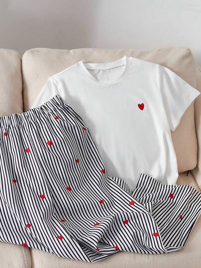 女童白色短袖T恤+阔腿裤套装，上衣为简约圆领T恤，左胸饰有红色爱心图案，清新俏皮；下装为黑白条纹阔腿裤，饰有同款爱心印花，宽松简约的版型，柔和的配色，甜美而不腻人，适合居家日常穿着或短途外出。