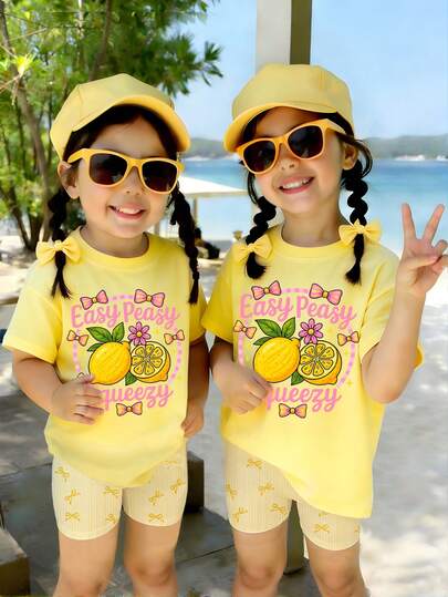 女婴春夏休闲时尚创意个性清新可爱简约柠檬花黄粉蝴蝶结星星黄条纹图案字母标语印花休闲基础款短袖T恤+骑行短裤套装，舒适日常穿着，适合春、夏、秋季女婴穿着。