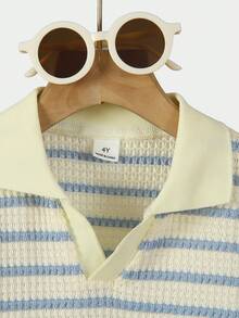 SHEIN Streecool Kids 这款男童休闲学院风华夫格条纹V领短袖POLO衫，适合4-7岁男孩春夏穿着。这款阳光男孩POLO衫既适合上学，也适合居家穿着。无论上学还是在家，男孩们都可以穿着这件休闲、舒适又时尚的POLO衫。这款上衣百搭，适合男孩们的日常生活和聚会场合。让男孩们保持时尚舒适，充满活力，无论是在与家人共度时光还是其他场合！ - 藍白色 - 查看 8