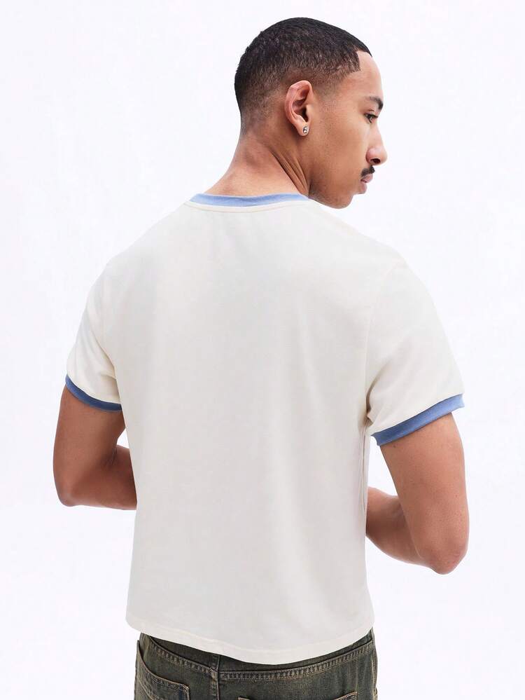 Camiseta com estampa gráfica e gola contrastante.