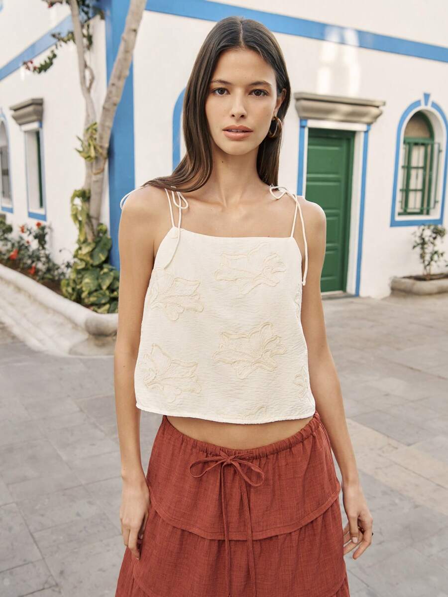 Nöista 白色露脐上衣饰有花卉刺绣，配有可调节的细吊带，吊带系成蝴蝶结。适合夏季、春季、复活节等场合，女士穿着。 - 白色 - 查看 1