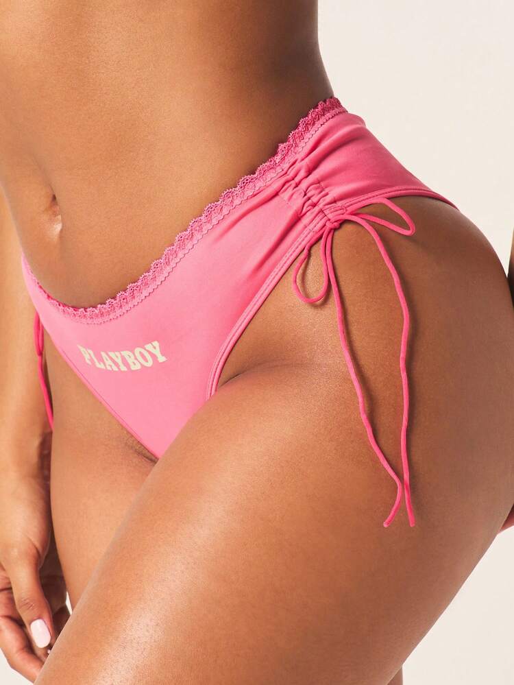 Missguided x Playboy Damskie stringi z logo, marszczeniami po bokach i koronkową lamówką oraz regulowanymi wiązaniami po bokach
