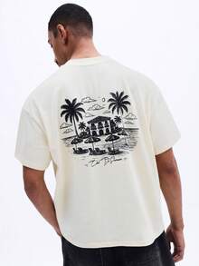 SUMWON Camiseta de manga corta con cuello redondo y ajuste boxy para hombres, con gráfico en la espalda con estampado de palmeras y casa de playa tropical para vacaciones de verano casual - Amarillo - Ver 1