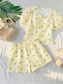 Sparklyn Bộ áo sơ mi cổ chữ V cho bé gái tuổi teen, điểm nhấn là những chiếc nơ cùng màu ở cổ áo và nẹp áo, tay áo ngắn phồng tạo nên vẻ ngọt ngào. Kết hợp với quần short rộng rãi cùng chất liệu, tạo nên phong cách giản dị và thoải mái, phù hợp để mặc ở nhà hoặc ngoài trời vào mùa hè. - Màu vàng - Xem 8