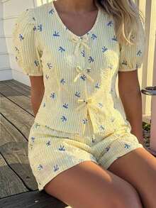 Sparklyn Bộ áo sơ mi cổ chữ V cho bé gái tuổi teen, điểm nhấn là những chiếc nơ cùng màu ở cổ áo và nẹp áo, tay áo ngắn phồng tạo nên vẻ ngọt ngào. Kết hợp với quần short rộng rãi cùng chất liệu, tạo nên phong cách giản dị và thoải mái, phù hợp để mặc ở nhà hoặc ngoài trời vào mùa hè. - Màu vàng - Xem 9