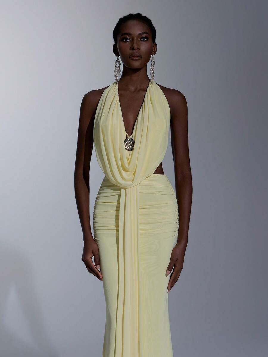 Elitara Vestido elegante amarelo claro em malha elástica de alta elasticidade com amarração no pescoço, decote profundo drapeado, babado frontal, detalhe metálico e costas abertas em formato de cauda de sereia. Ideal para encontros, férias, praia, compras, festas de solteiros, casamentos, formaturas e para a primavera/verão.