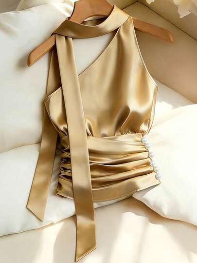 Franclia 女士春夏新款优雅香槟金金属光泽珍珠装饰单肩吊带上衣，采用缎面光泽针织弹力面料制成，配有单肩吊带和领口系带，侧边饰有珍珠，腰部褶皱设计，适合派对和晚宴场合。产品特点：女士金属光泽单肩吊带背心，领口系带褶皱腰部上衣，侧边珍珠装饰吊带背心，派对和鸡尾酒会叠穿单品，奢华晚装。