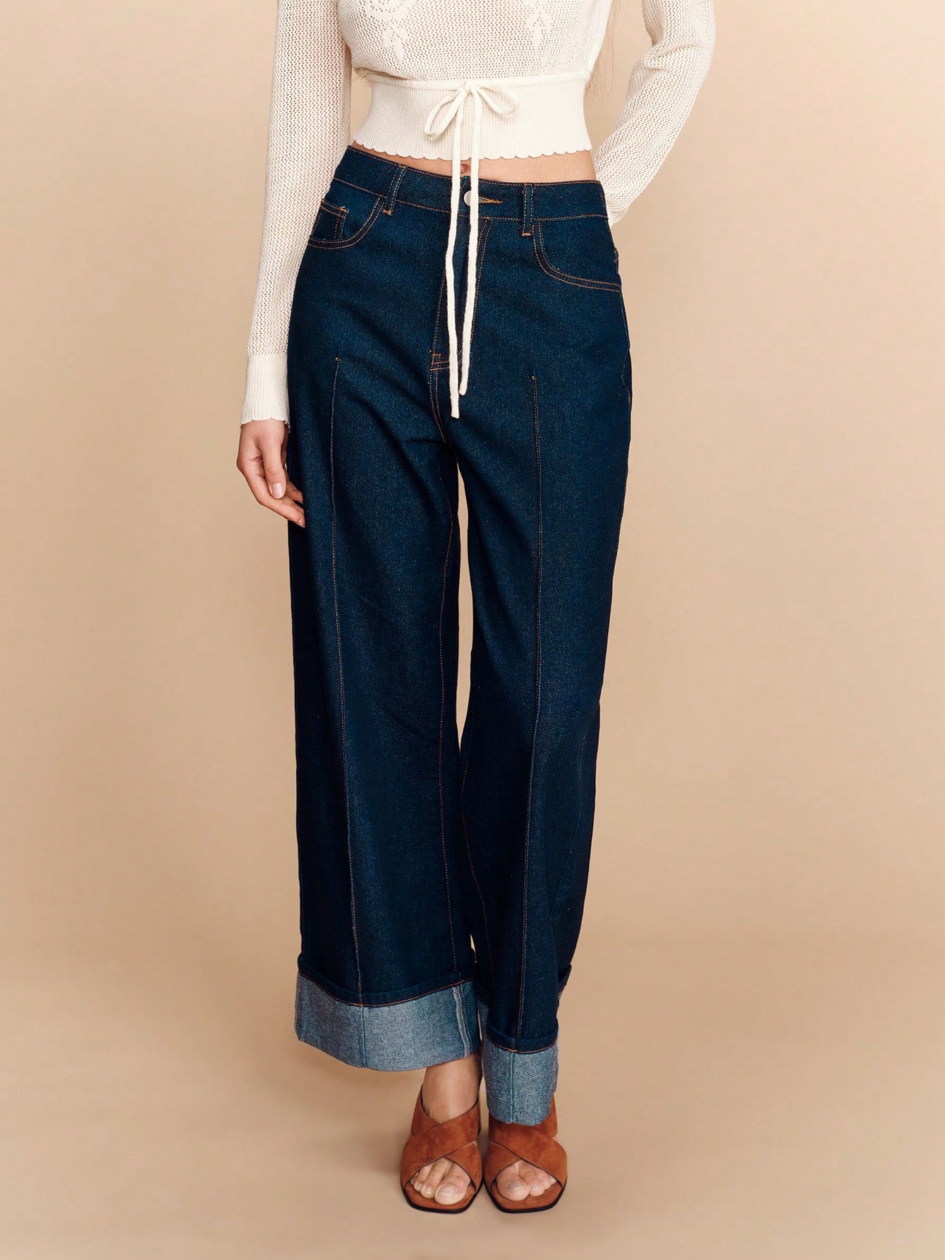 Jeans larges taille haute en denim foncé avec pli avant et ourlet relevé. Pantalon en denim élégant pour le printemps et l'été, dans un style français parisien