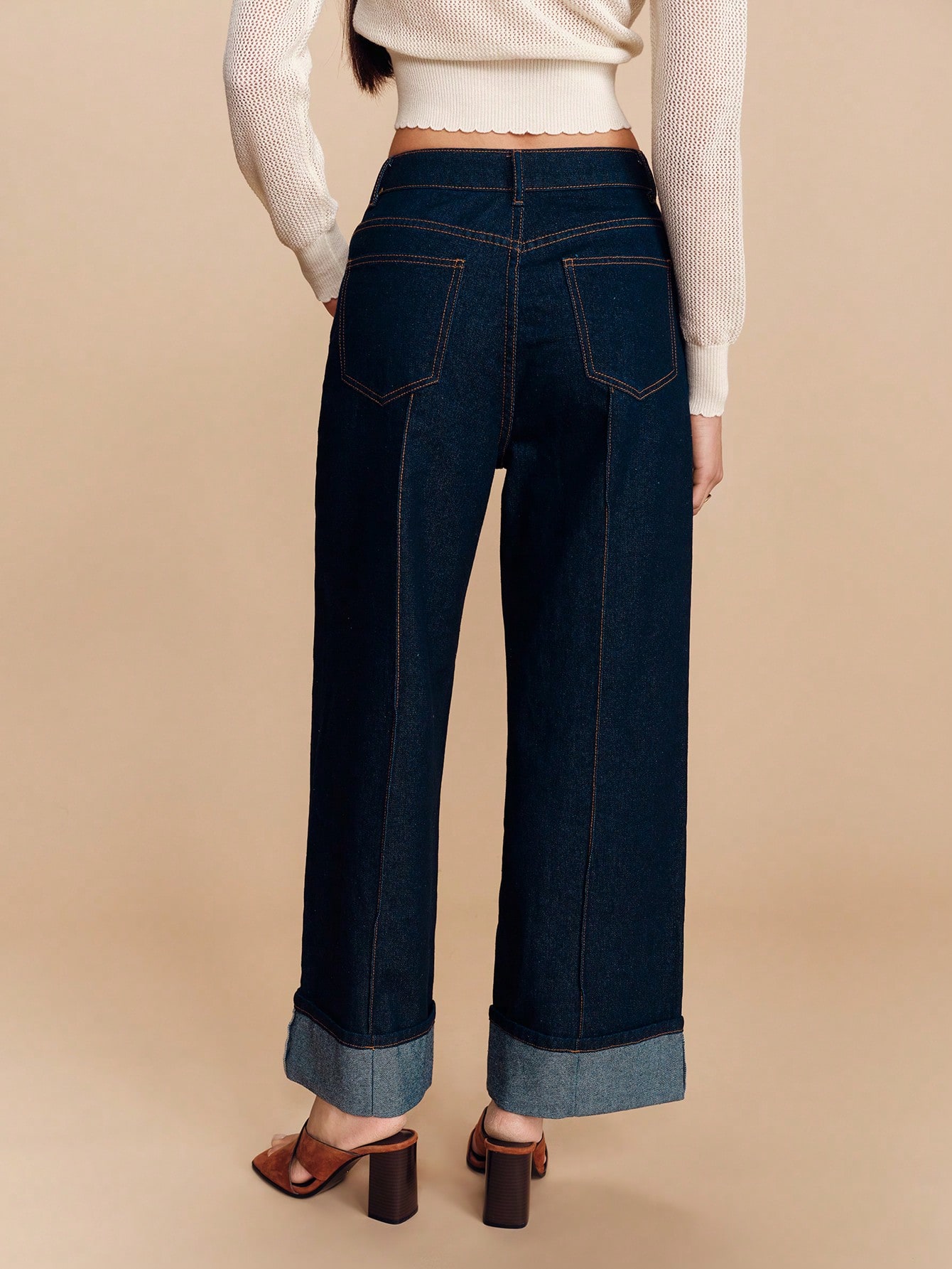 Jeans larges taille haute en denim foncé avec pli avant et ourlet relevé. Pantalon en denim élégant pour le printemps et l'été, dans un style français parisien