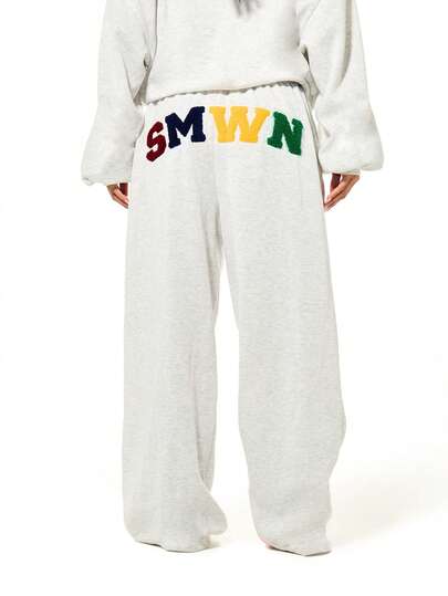 SUMWON WOMEN 彩色字母贴花套头连帽衫，带抽绳和中央口袋，适合休闲街头服饰和世界杯主题。