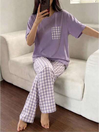 一套少女睡衣套装，薰衣草色短袖上衣带口袋设计，搭配紫白格子裤，简约清新风格，面料柔软透气，宽松版型适合日常穿着，色调和谐，设计简洁易搭，为少女打造舒适休闲的造型。