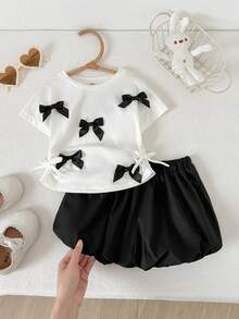 Cozy Pixies Conjunto de 2 piezas de top de manga corta con cuello redondo y decoración de lazo, y shorts de cintura elástica en bloques de color para niña bebé, conjunto casual para vacaciones - Blanco y Negro - Ver 11