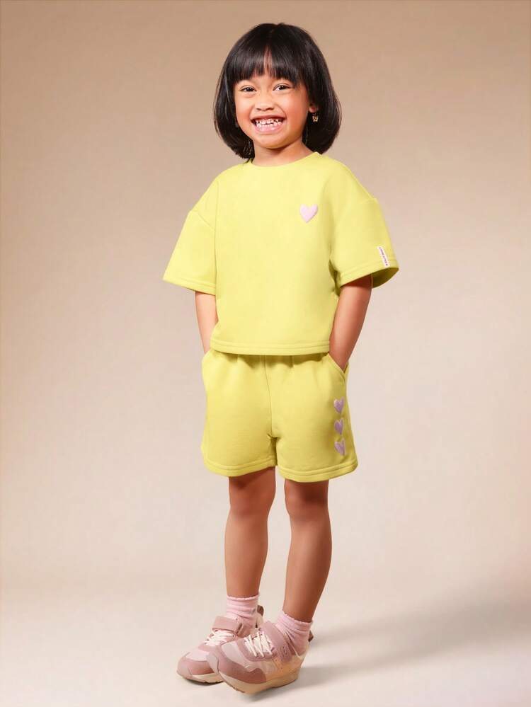 Set coordinato da ragazza con maglietta a girocollo a maniche corte e pantaloncini in verde lime, con dettagli a stampa a cuore