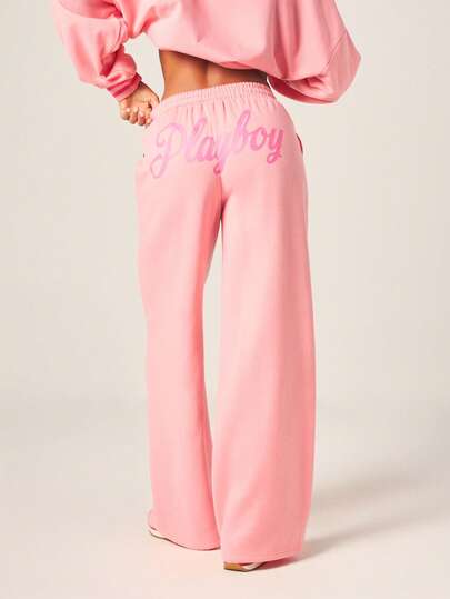 Missguided x Playboy Pantalones de chándal de pernera ancha y cintura alta de terciopelo rosa con logotipo de texto y cintura elástica para uso informal