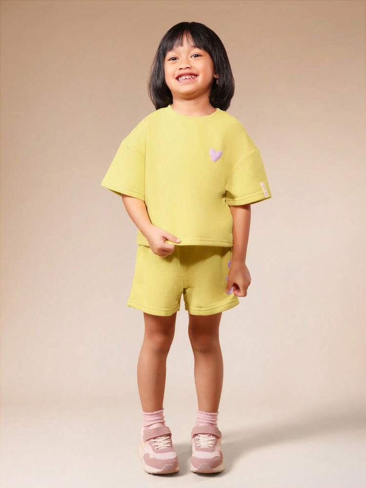 Set coordinato da ragazza con maglietta a girocollo a maniche corte e pantaloncini in verde lime, con dettagli a stampa a cuore